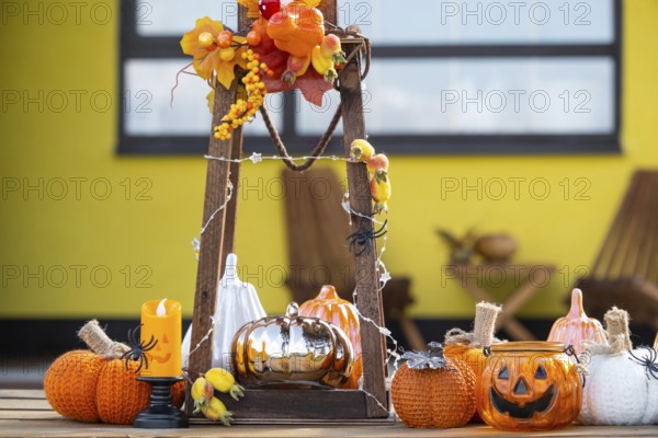 Autumn decor on the porch of the house outside in the yard of pumpkin, lantern, garlands, hats,