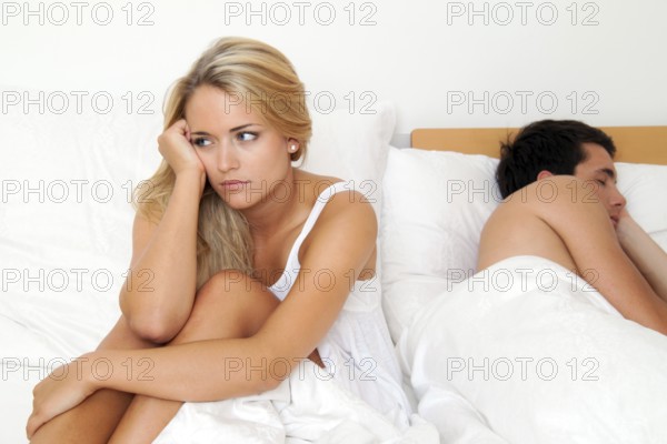 A young couple in bed having problems and crisis. Divorce and separation, A young couple in bed