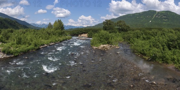 Stunning summer panoramic landscape of Kamchatka Peninsula: view of stream clear water of mountain