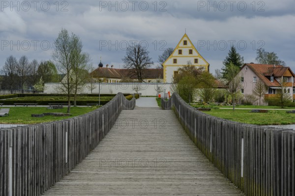 Wooden bridge leads to a historic building in a green park landscape, Tirschenreuth, Upper