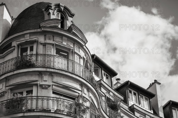Details of a residential building with curved walls, balconies and ornate iron railings in Paris,