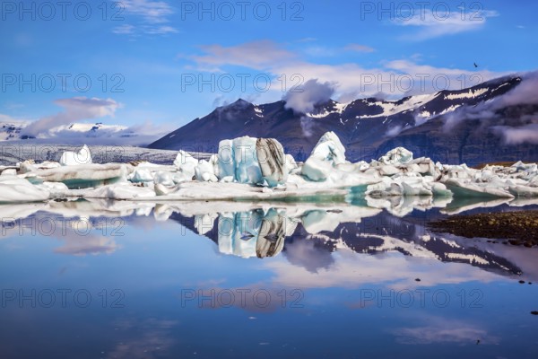 Icebergs and ice floes are reflected in the smooth water surface. Drift ice Ice Lagoon -