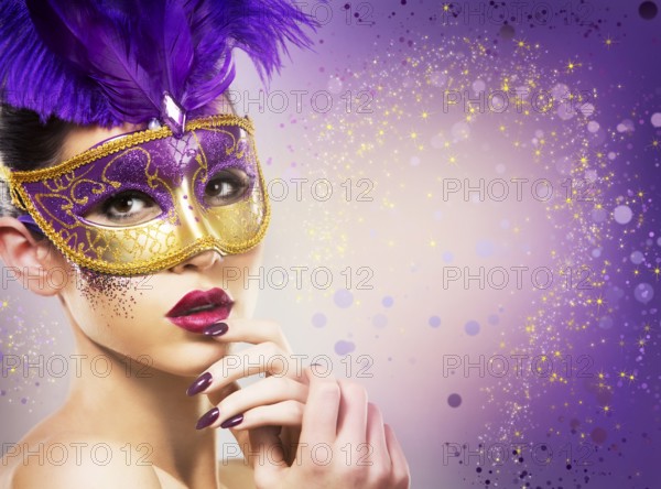 Beautiful woman with dramatic mekaup and pruple lipstick wearing puprle mask. Light background.