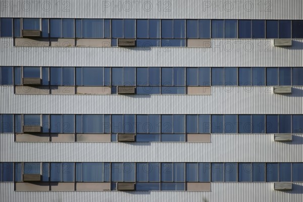 The modern façade and exterior wall of an office building with solar control windows and air