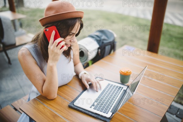 Theme tourism and travel young student. beautiful young Caucasian girl in dress and hat sits in