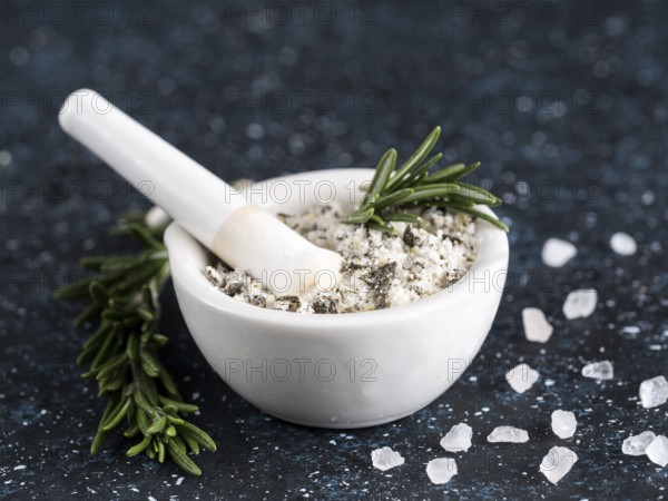 Close up view of mortar and pestle with sea salt scented rosemary and lemon zest. Sea salt scented