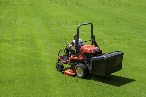 Mowing grass at the football stadium in Lubin, Poland, Europe