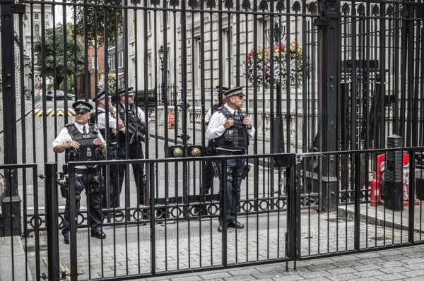 London, UK, August 18, 2015: Police officers protecting the gate of Downing street in London, the