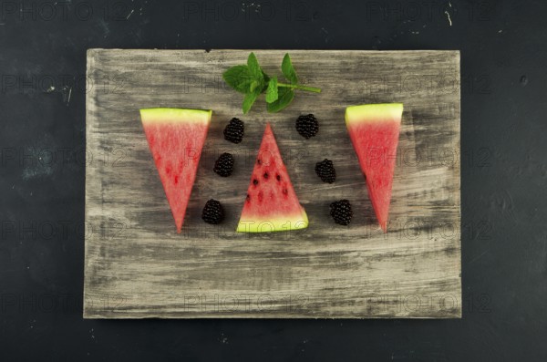 WATERMELON BLACKBERRY AND MINT ON THE BACKGROUND. THREE PIECES OF RIPE JUICY WATERMELON WITH RIPE
