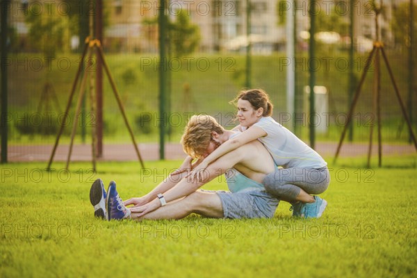 Young in love heterosexual Caucasian couple, man with beard woman with big breasts doing exercise