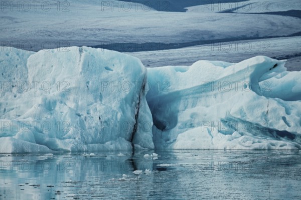 Large ice formations in a serene icy landscape with reflections on water, iceberg, glacier, snow,