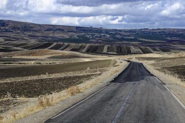 On the way to Fes, Morocco, A winding country road stretches through a hilly landscape surrounded