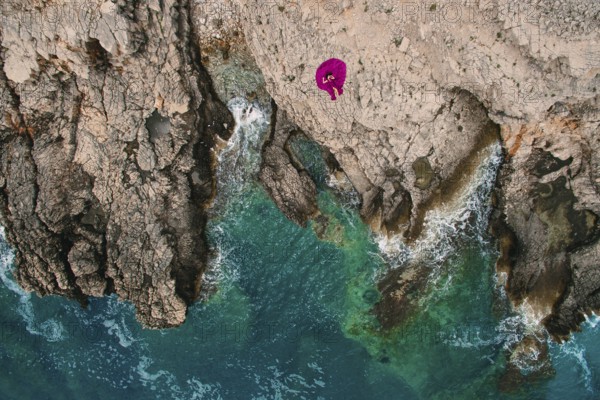 A girl in a purple dress rests on a rocky beach in Montenegro, aerial photography, Herceg Novi,