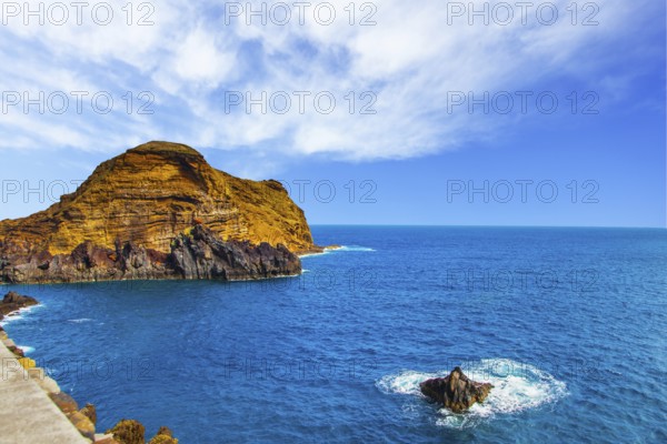 Calm bay with azure water. Rocks and stones off the shores of the volcanic island of Madeira. The