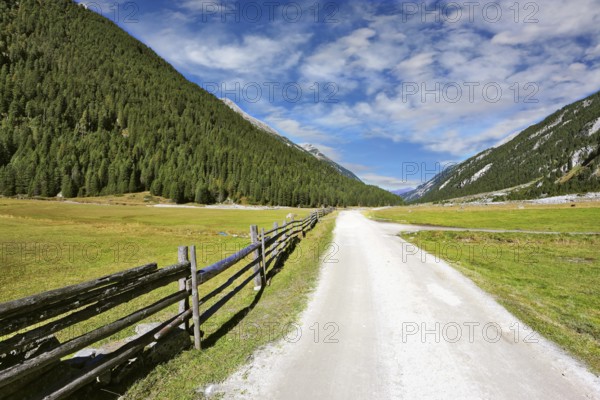 Headwaters National Park Krimml waterfalls. Rural idyll. Farm fields separated from the dirt road a