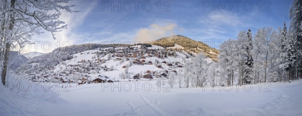 Panoramic winter scene of snow covered La Clusaz village nestled in a hilly landscape in Annecy,