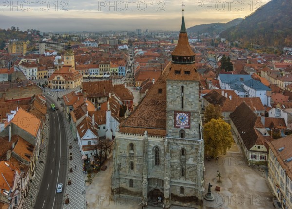 Aerial view of Brasov old town with Black Church and Piata Sfatului square in autumn morning,