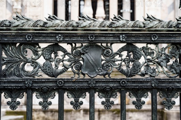 Antique wrought iron fence near the Duomo Cathedral in Milan with spikelets, shields, flowers and