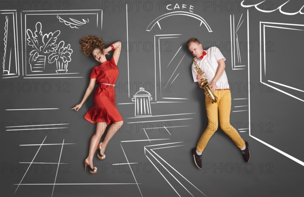 Love story concept of a romantic couple against chalk drawings background. Male playing the