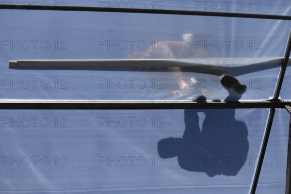 GREYMOUTH, NEW ZEALAND, DECEMBER 12, 2018: A tradesman is seen in silhouette as he secures the