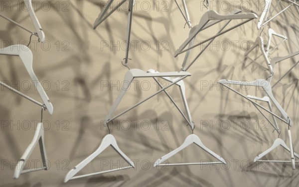 Empty wooden clothes hangers casting deep shadows. Real coat hanger wood pattern. Abstract fashion