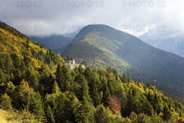 Travel to Slovenia. Ruins of a medieval castle on a mountainside. The mountain road passes through