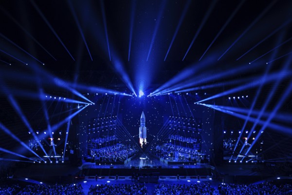 Futuristic-looking concert stage, illuminated in blue with a central rocket motif, Il Volo concert,