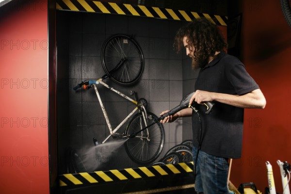 Services professional washing of a bicycle in the workshop. Close-up of hand Young Caucasian
