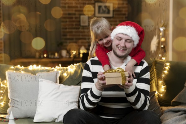 Merry Christmas and Happy New Year. Christmas gift surprise. A little smiling daughter girl hugging