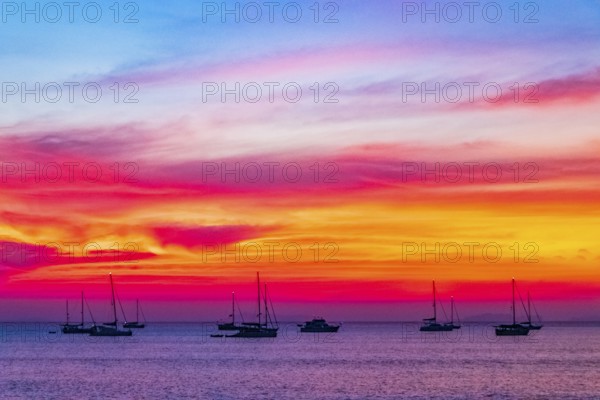 Yachts boats in front of the most beautiful colorful sunset at Tropical Paradise island Koh Phayam