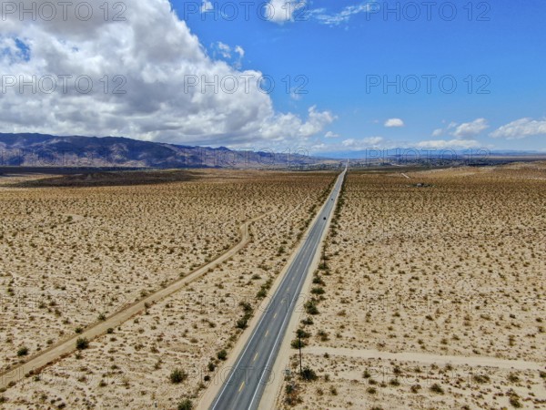 Aerial view of endless desert straight dusty asphalt road in Joshua Tree Park. USA. Long straight