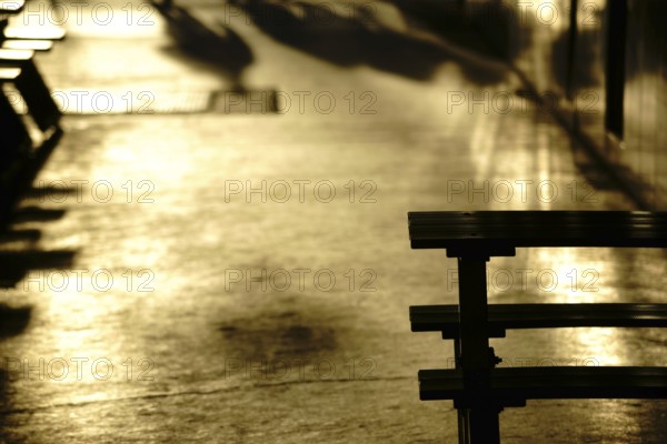 Gold-coloured light reflections in a corridor or passageway of a shopping street with shadows and