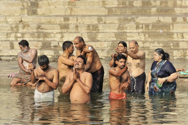Varanasi, Uttar Pradesh, India, Asia, A group of people perform spiritual rituals in a river, in a