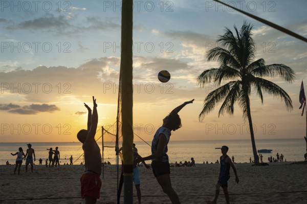 18.11.2019, Phuket, Thailand, Asia, A group of locals playing volleyball on Karon Beach at sunset,