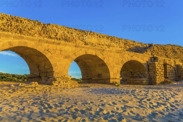 Stunning sunset on the Mediterranean coast in Israel. Well-preserved aqueduct, built in Caesarea at