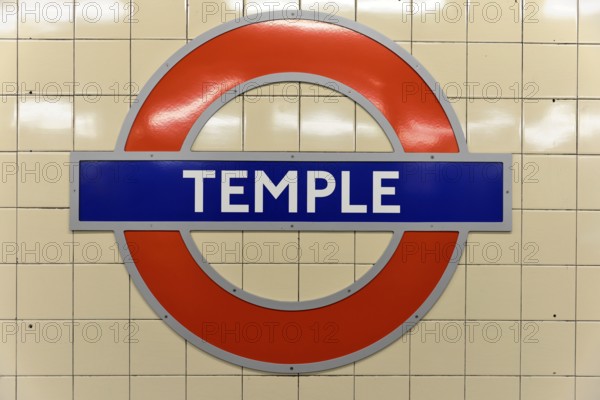 The red and blue Tube logo of Temple Station on a tiled background, London, London region, England,