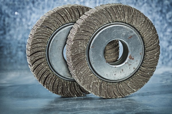 Two abrasive flap discs on metalic background