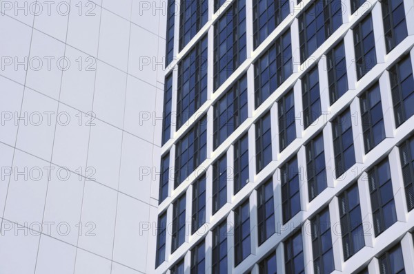 Close up detail of tall high rose modern apartment buildings with white cladding and dark windows