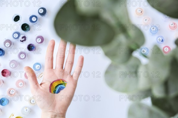 Rainbow LGBTQ flag painted on hand. Support for lgbt community. Honour of pride month. Connecting