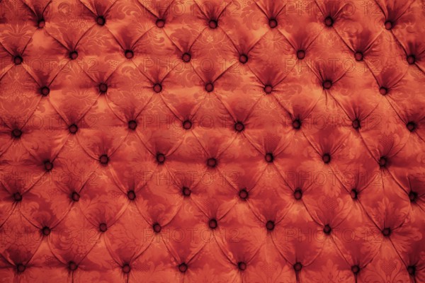 Close up background texture of scarlet red capitone genuine leather, retro Chesterfield style soft