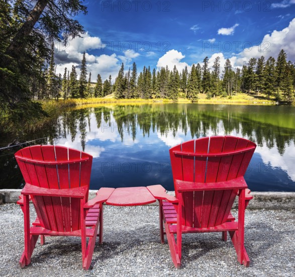 Jasper National Park in the Rocky Mountains. Two red plastic chairs on the lake. On shores of the