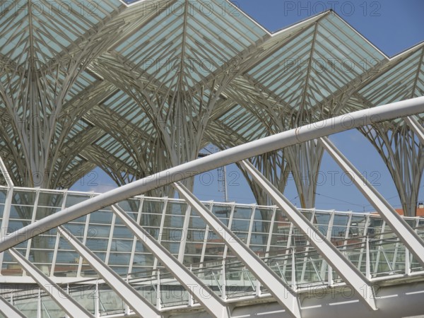 Architectural details of a modern structure with glass roof and steel construction against blue
