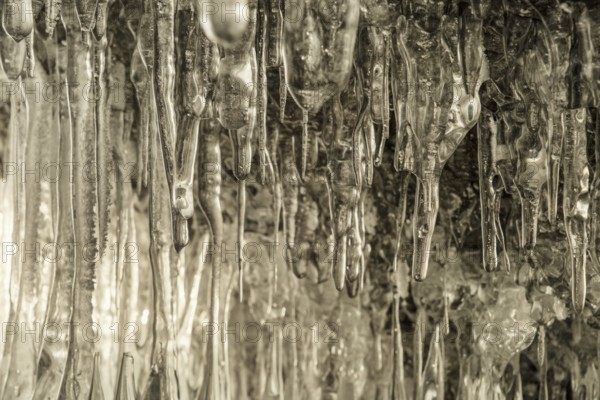 Ice cave on Baikal lake in winter. Clear transparent ice and icicles in grotto. Olkhon island,