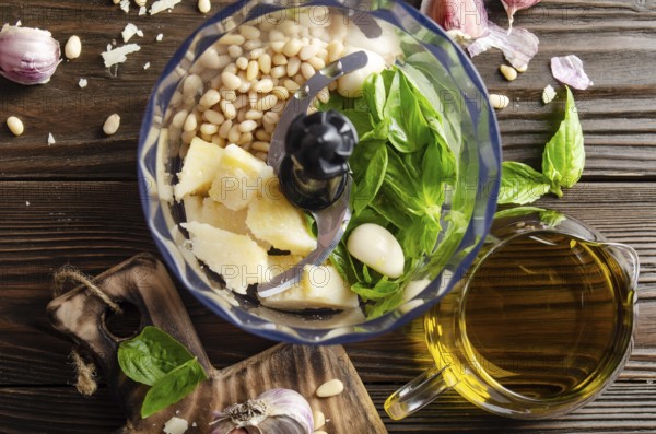 Ingredients for italian national traditional genovese pesto sauce in food processor bowl. Flat lay
