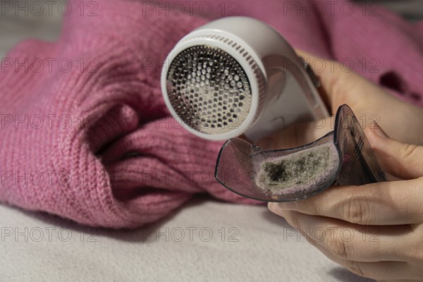 Woman using Anti-pilling razor at home. Device for shaving clothes. Anti-Plush fabric Shaver.