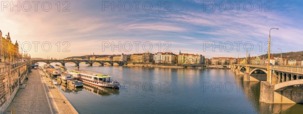 Colorful panorama with the Vltava river, its bridges and the buildings of Prague city, on a sunny