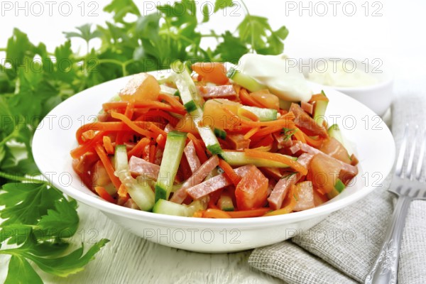 Salad from smoked sausage, spicy carrot, tomato, cucumber and spices with mayonnaise, kitchen