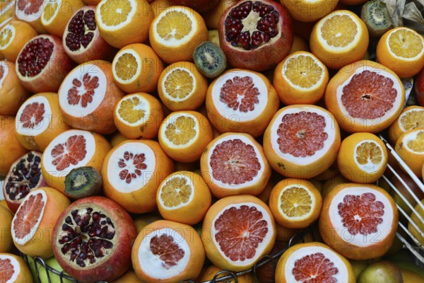 Sliced fruits such as oranges, pomegranates and kiwis show their colourful inner structure,
