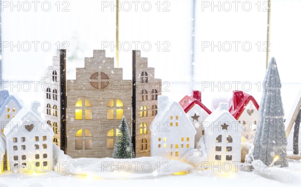 Cozy Christmas decor tiny house of small size on window sill with snow outside the window. Gift for