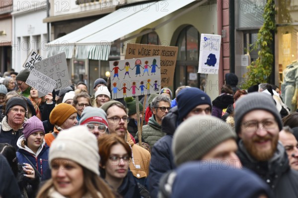 Heidelberg, Germany - February 12th 2025: Person holding up sign showing drawing of people of color